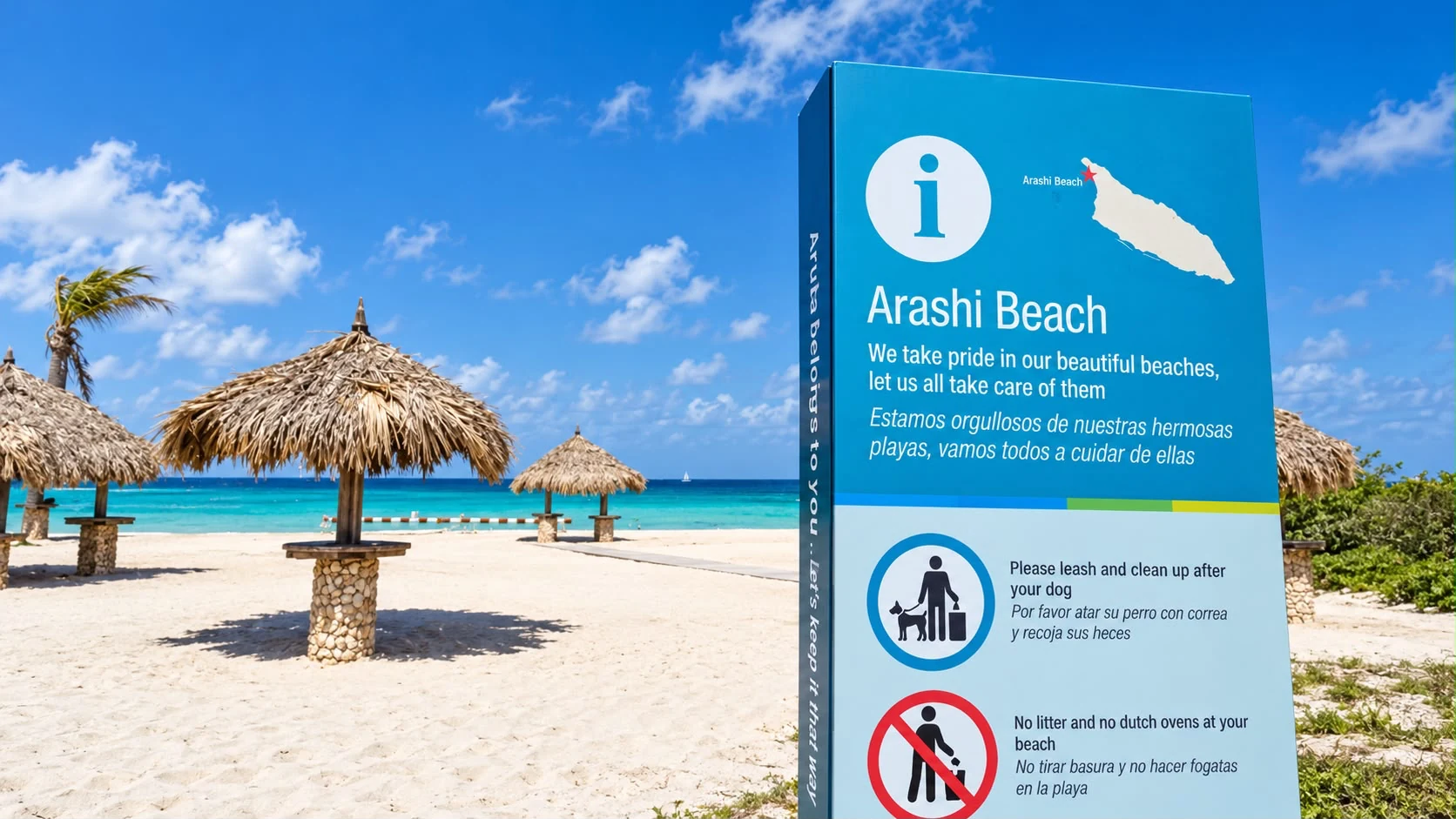 Arashi Beach’s information sign, with thatched palapas and turquoise water behind it