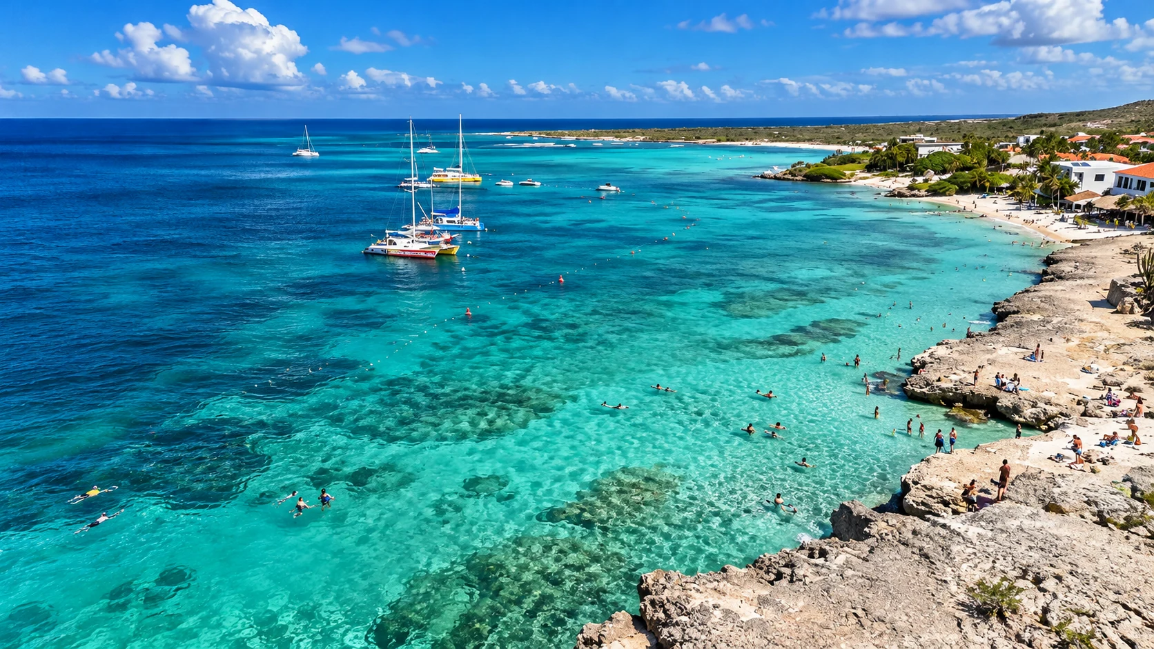 Turquoise water, swimmers and sailboats along Tres Trapi’s rocky coastline