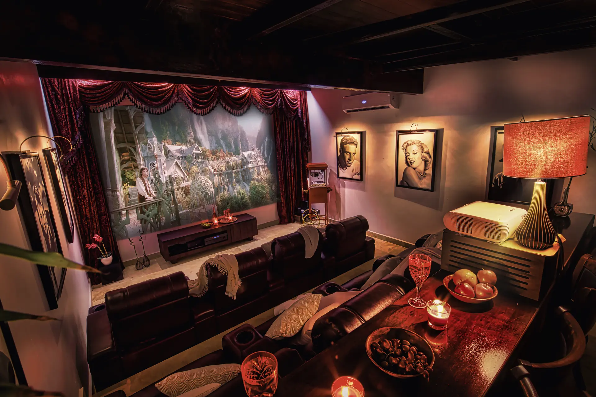 The Bali Cinema at Bali Retreat Aruba, with its large projection screen, burgundy curtains, leather recliners and rear bar