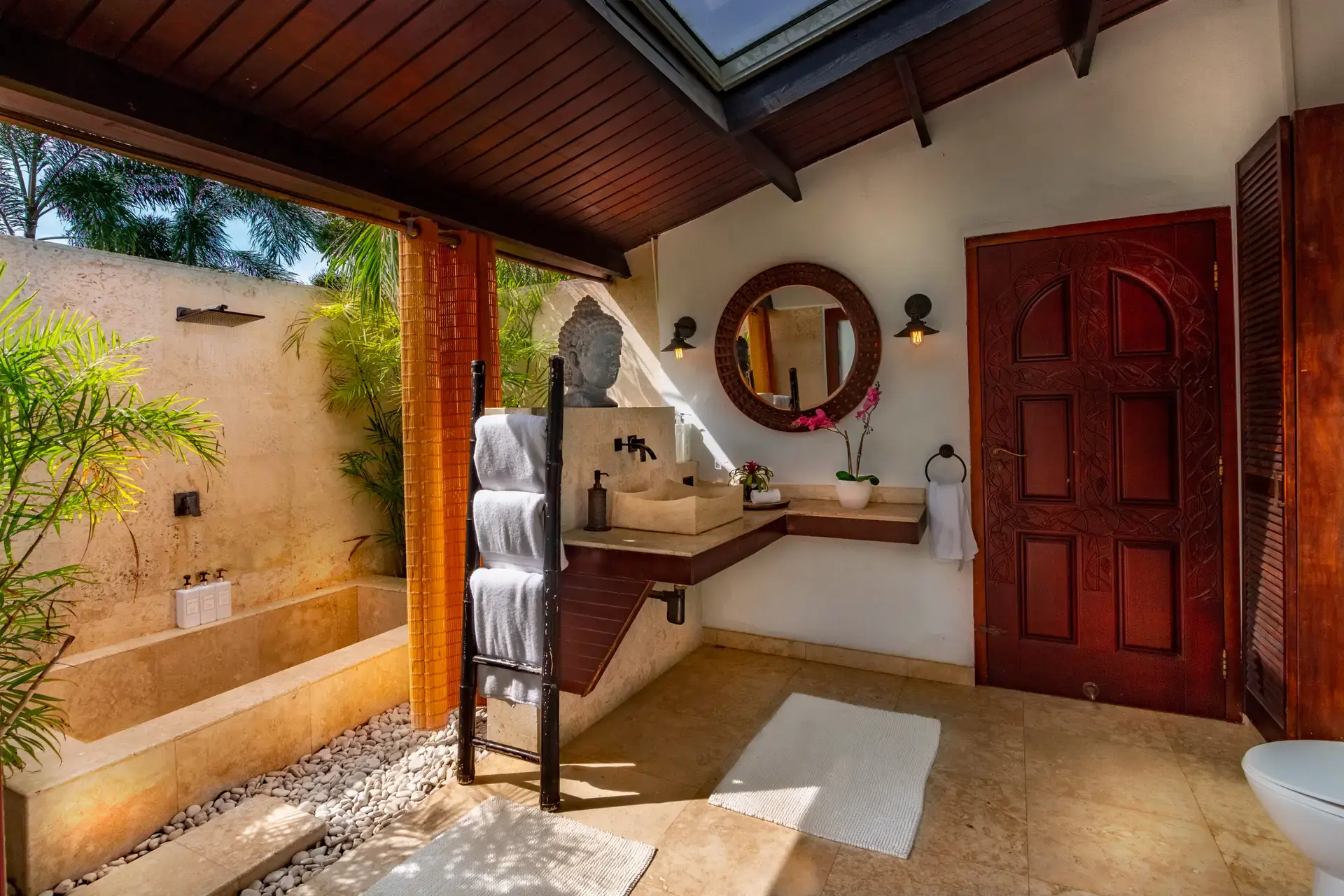 Private tropical open-air bathroom with outdoor shower in the Beach Suite at Bali Retreat Aruba.